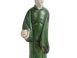 une figurine représentant un homme tenant une balle, posée sur une surface blanche