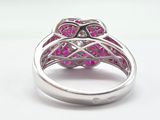an image of a ring with pink stones on a white surface
