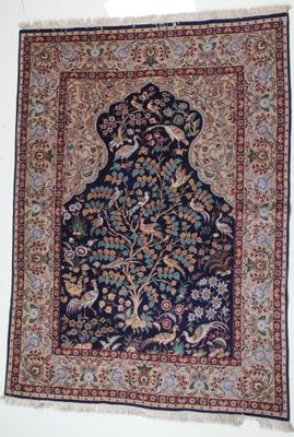 un tapis oriental accroché au mur, orné d'oiseaux et de fleurs