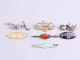 plusieurs types de broches et d'épingles disposés sur un fond blanc