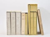 trois livres sont empilés sur une surface blanche