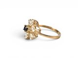 an image of a gold ring with a black and white stone