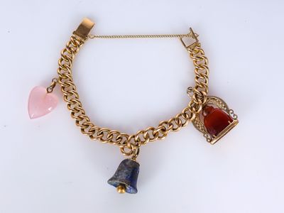 a close up of a gold chain bracelet with charms