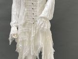 an image of a mannequin wearing a white dress with fringes on it