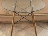 a glass table with wooden legs and a glass top