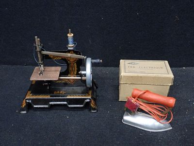 une petite machine à coudre posée à côté d'une boîte sur une table