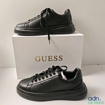 black leather sneakers with a gold logo on the side