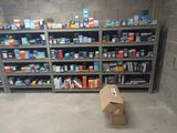 une boîte en carton posée par terre devant une étagère remplie de cigarettes