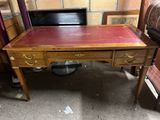 un bureau en bois avec un plateau en cuir rouge