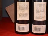 three bottles of wine sitting on a red table