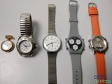 four different watches are lined up on a white surface