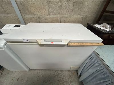 a white dishwasher sitting on the floor next to a trash can