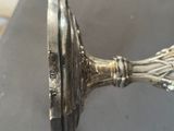 a close up of a silver candle holder on a table
