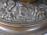 a close up of a bronze statue of a bird on a branch