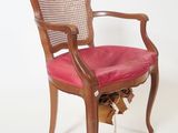 a wooden chair with a pink seat and a basket underneath it