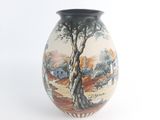 a vase with a painting on it sitting on a table