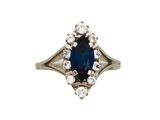 un gros plan sur une bague sertie d'un saphir bleu et de diamants