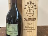 une caisse en bois contenant une bouteille de vin à côté d'un morceau de fromage