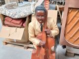 une statue représentant un homme tenant un violoncelle dans un magasin