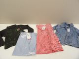 Trois paires de vêtements pour enfants sont alignées sur une table