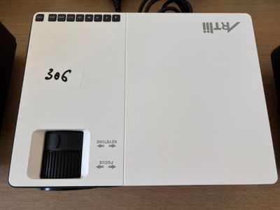 un projecteur blanc surmonté d'une télécommande