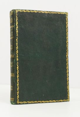 an old book sitting on top of a white table next to a white wall