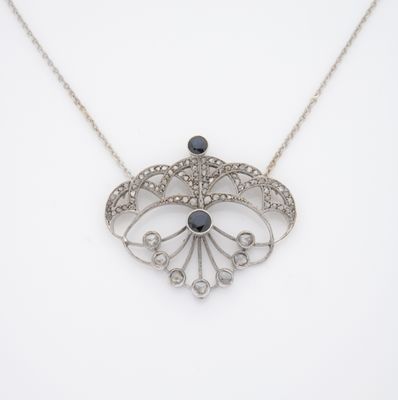 un collier en argent orné d'une pierre noire et de diamants blancs