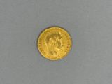 a close up of a gold coin on a gray surface