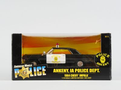 une petite voiture de police dans une boîte, posée sur une surface blanche