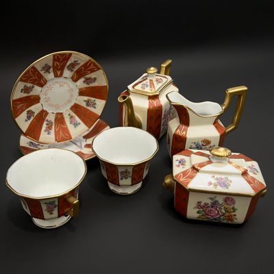 une image représentant un ensemble d'objets en porcelaine posés sur une surface noire