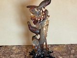 a statue of a bird sitting on a tree branch