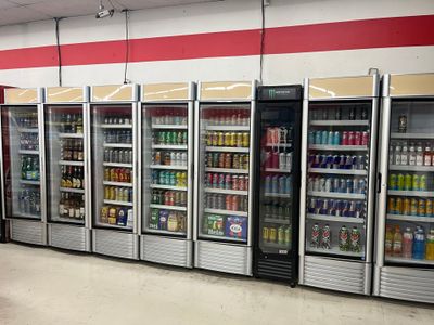 a row of refrigerators in a store filled with drinks