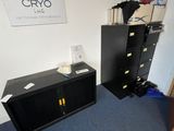 two black filing cabinets in a room with a sign on the wall