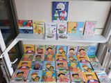 many children ' s books on the shelves in the room
