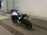 a white and blue motorcycle parked on the side of the street