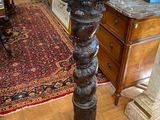 a tall wooden table with a vase on top of it