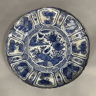 a blue and white plate with flowers and birds on it