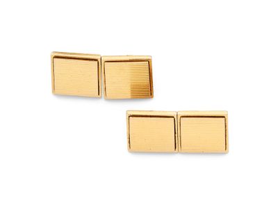 une paire de boutons de manchette plaqués or sur fond blanc