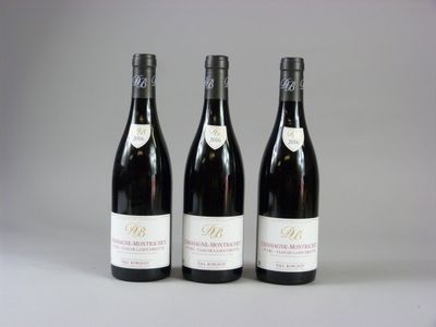 trois bouteilles de vin sont alignées sur une table
