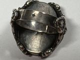 gros plan d'une bague en argent sur une surface blanche