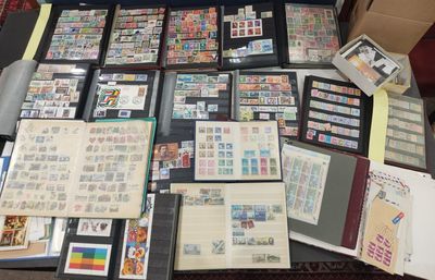 beaucoup de timbres posés sur une table, à côté d'un ordinateur portable