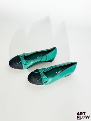 une paire de chaussures vertes posées sur une surface blanche, avec un fond blanc