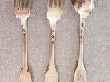 trois fourchettes et deux cuillères sur la table