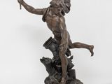 a bronze statue of a man holding a torch in his hand