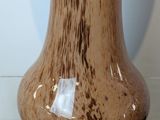 a brown vase sitting on top of a marble table
