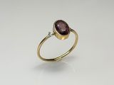 a gold ring with a purple stone and a diamond