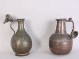two metal vases sitting next to each other on a table