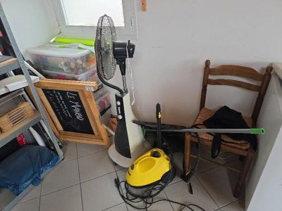 a small room with a fan and a chair in it