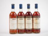 trois bouteilles de vin posées les unes à côté des autres sur une surface blanche