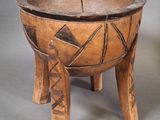 an old wooden bowl sitting on top of a wooden stand